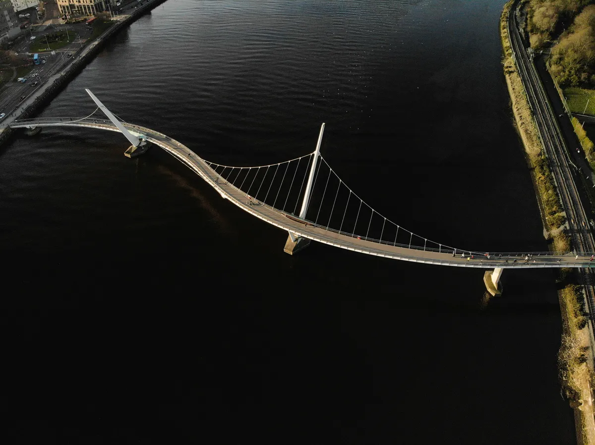 Aerial view of the Peace Bridge over the River Foyle in Derry, Northern Ireland, symbolising the infrastructure connecting data systems.